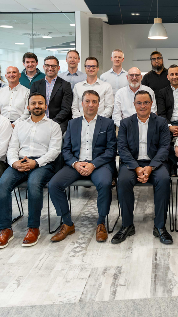 Large team of smiling colleagues, sitting together for a team photo